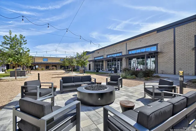 a living room with patio furniture and a potted plant