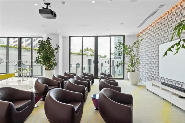 a living room with furniture and a floor to ceiling window