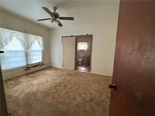 a view of a livingroom with a ceiling fan and window