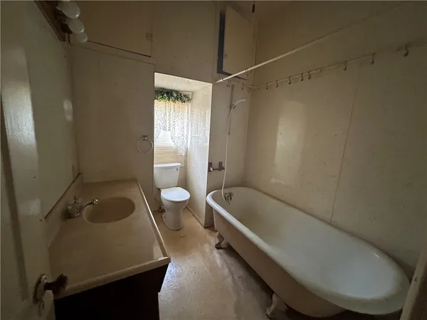 a bathroom with a tub a toilet and a sink