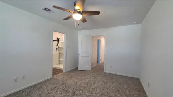 an empty room with a ceiling fan and a window