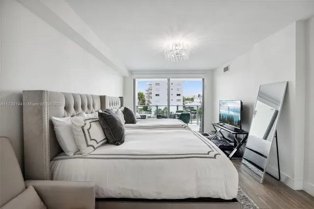 a bedroom with a large bed and a chandelier