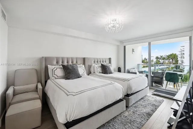 a bedroom with a large bed and a chandelier