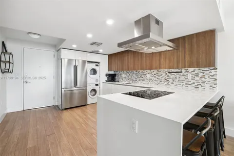 a kitchen with stainless steel appliances a stove a sink a refrigerator and a oven