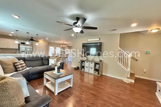 a living room with furniture and a wooden floor