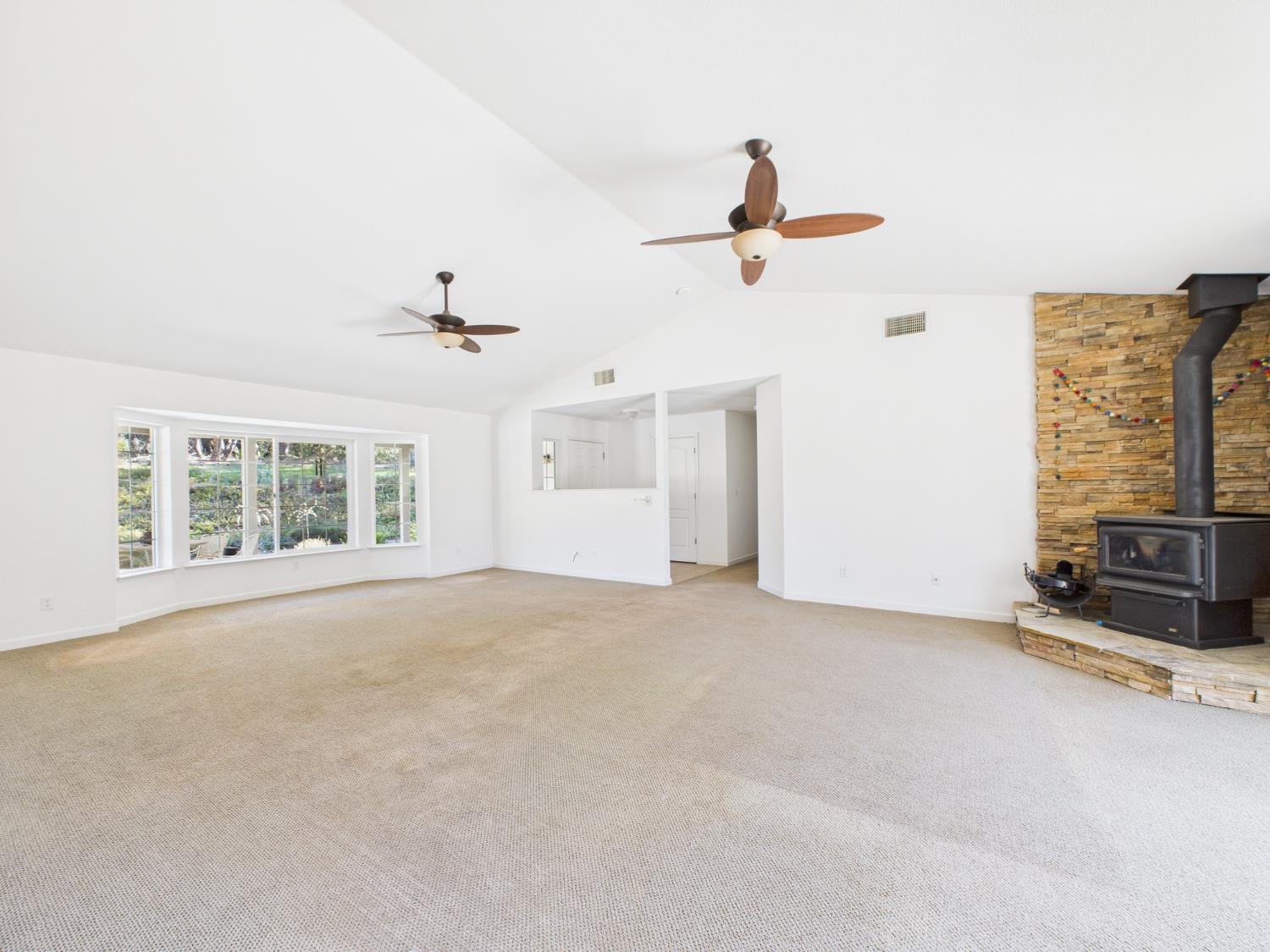 37550 Mountain Lakes Road Oakhurst, CA 93644 - Photo 11 of 63 an empty room with windows and ceiling fan