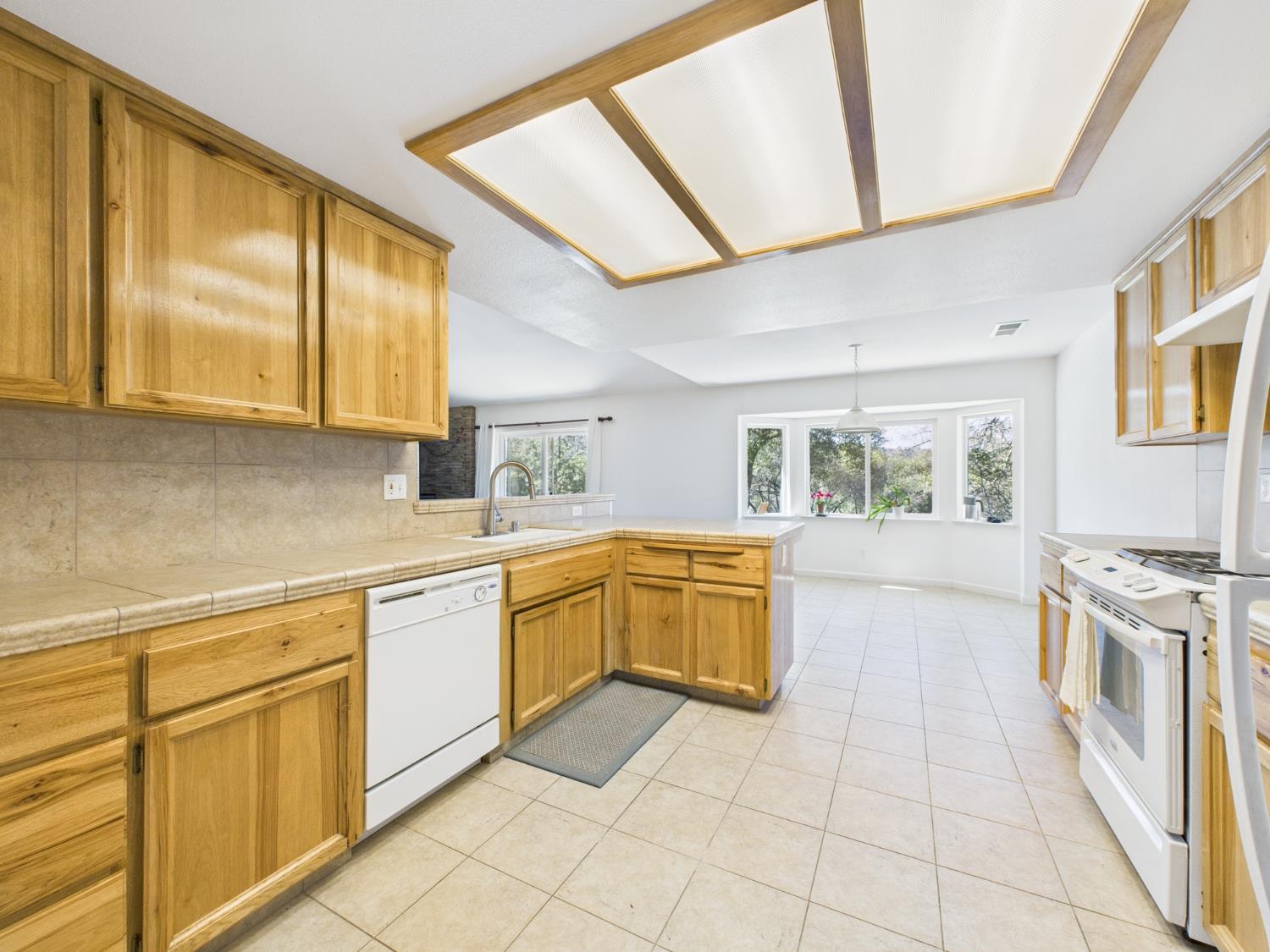 37550 Mountain Lakes Road Oakhurst, CA 93644 - Photo 17 of 63 a kitchen with a stove a sink and a refrigerator