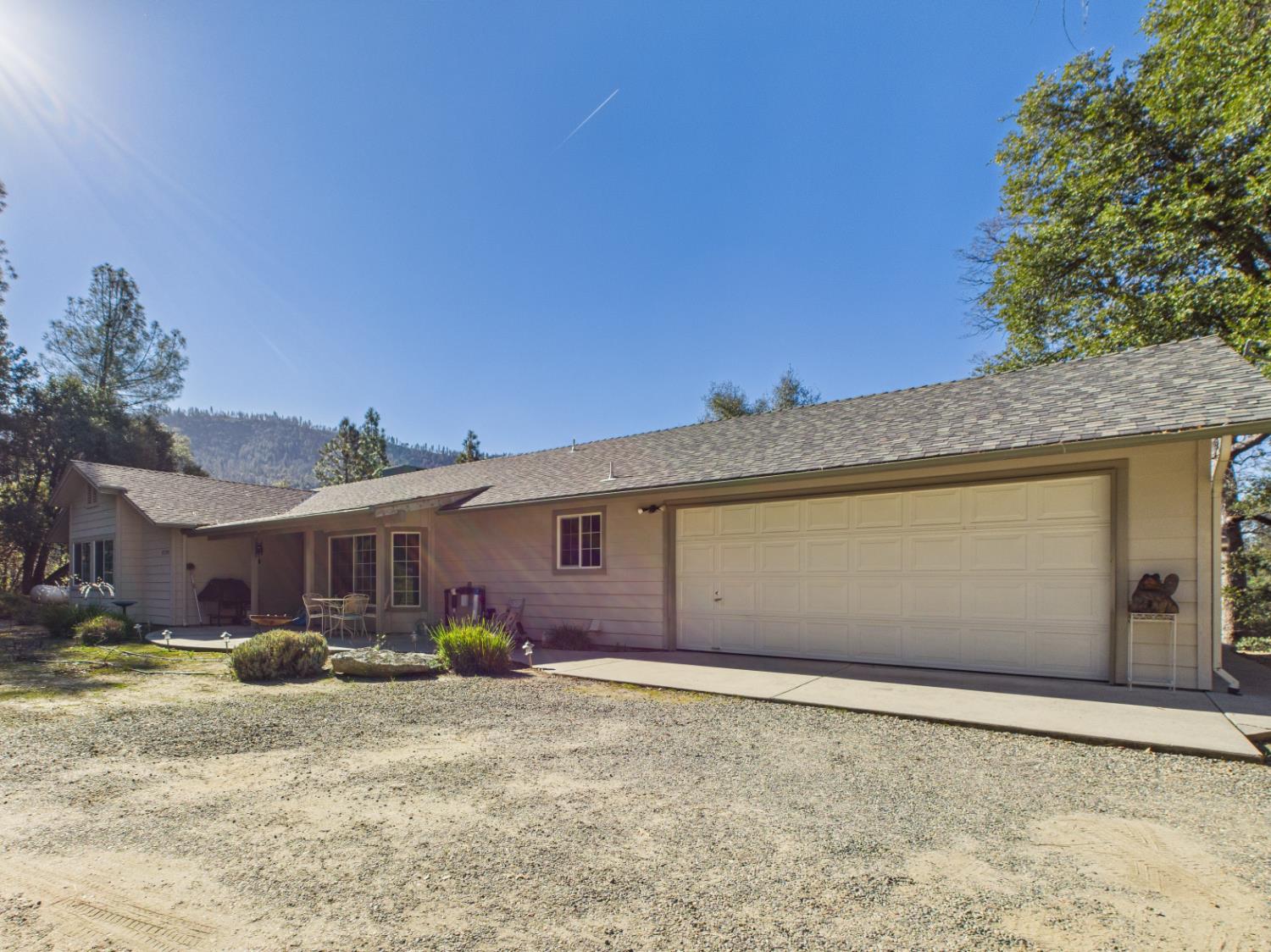 37550 Mountain Lakes Road Oakhurst, CA 93644 - Photo 2 of 63 a front view of a house with a yard and garage