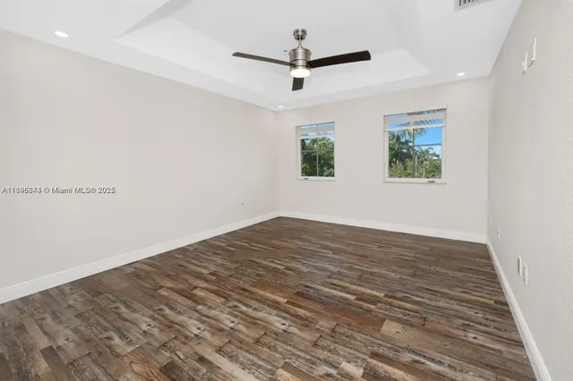 a view of empty room with wooden floor and window