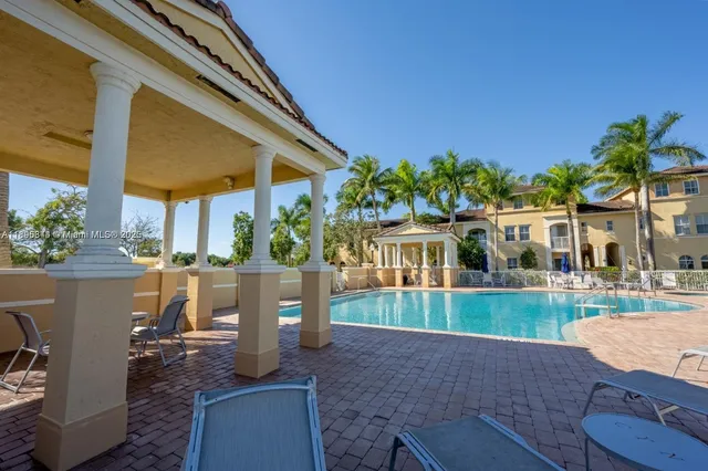a view of a swimming pool with chairs in patio