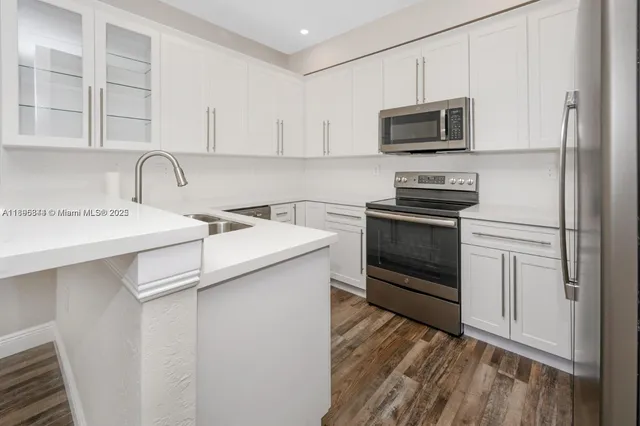 a kitchen with stainless steel appliances a stove microwave and sink