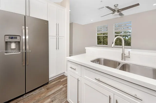 a view with granite countertop a refrigerator and a sink