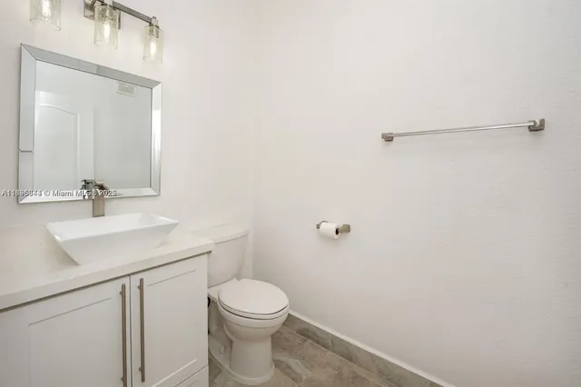a bathroom with a toilet a sink a vanity and mirror