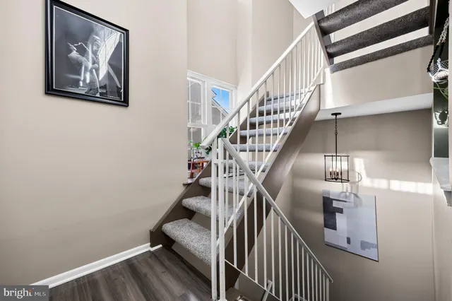 a view of a dining room and livingroom with furniture wooden floor a chandelier