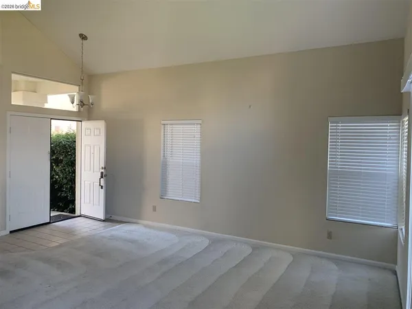 a view of empty room with fireplace and window