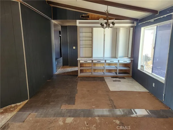 a view of an empty room with wooden floor and windows