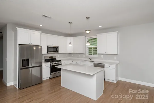 a kitchen with a refrigerator a sink and a stove top oven
