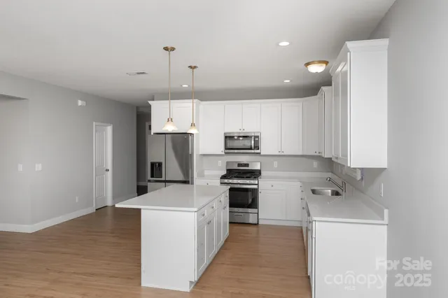 a kitchen with stainless steel appliances a refrigerator stove microwave and cabinets