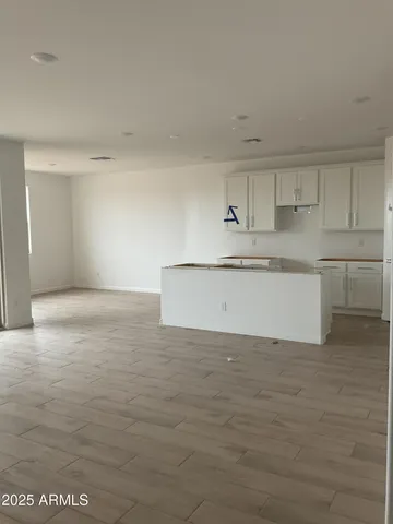 a view of a kitchen with white cabinets and wooden floor