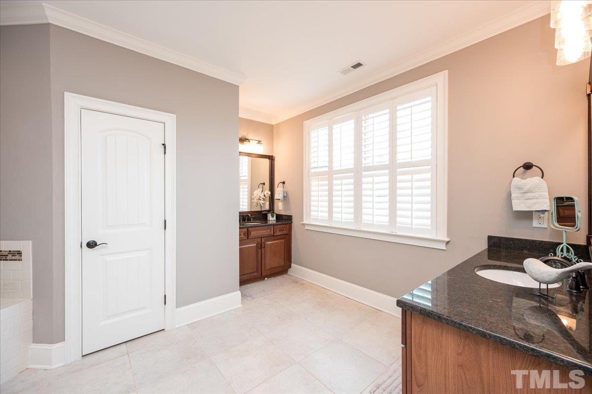 5100 Gansett Lane Raleigh, NC 27612 - Photo 19 of 39 a bathroom with a granite countertop sink a bathtub and window