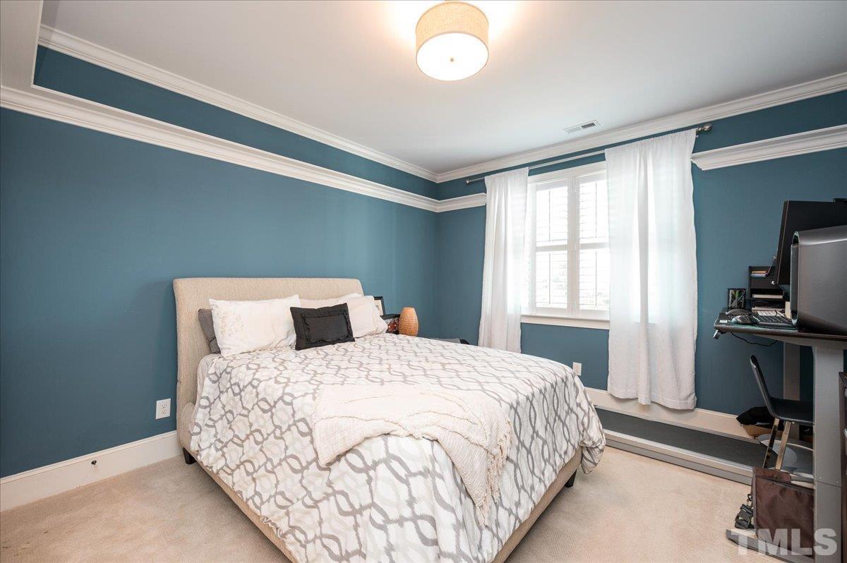 5100 Gansett Lane Raleigh, NC 27612 - Photo 22 of 39 a bedroom with a bed and a flat tv screen on the dresser