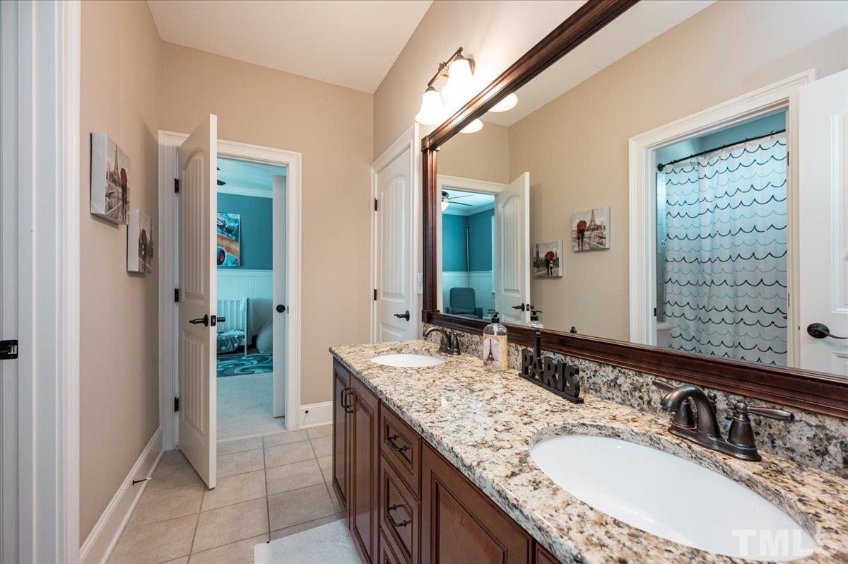 5100 Gansett Lane Raleigh, NC 27612 - Photo 23 of 39 a bathroom with a granite countertop double vanity sink and a mirror