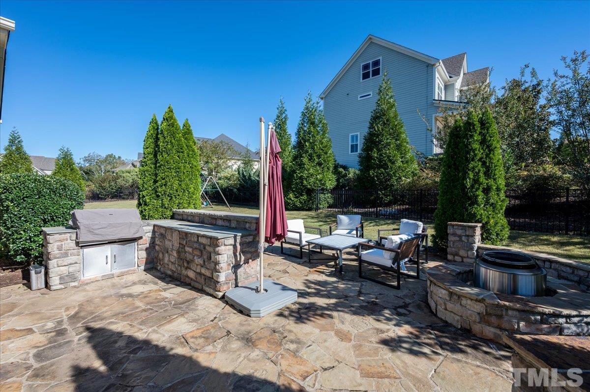 5100 Gansett Lane Raleigh, NC 27612 - Photo 30 of 39 a view of a patio with a dining table and chairs with a fire pit