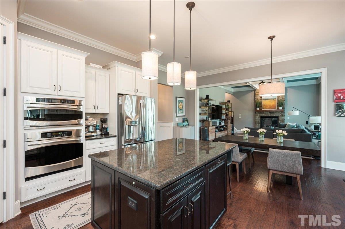 5100 Gansett Lane Raleigh, NC 27612 - Photo 3 of 39 a kitchen with stainless steel appliances granite countertop a stove a refrigerator a kitchen island a dining table and chairs