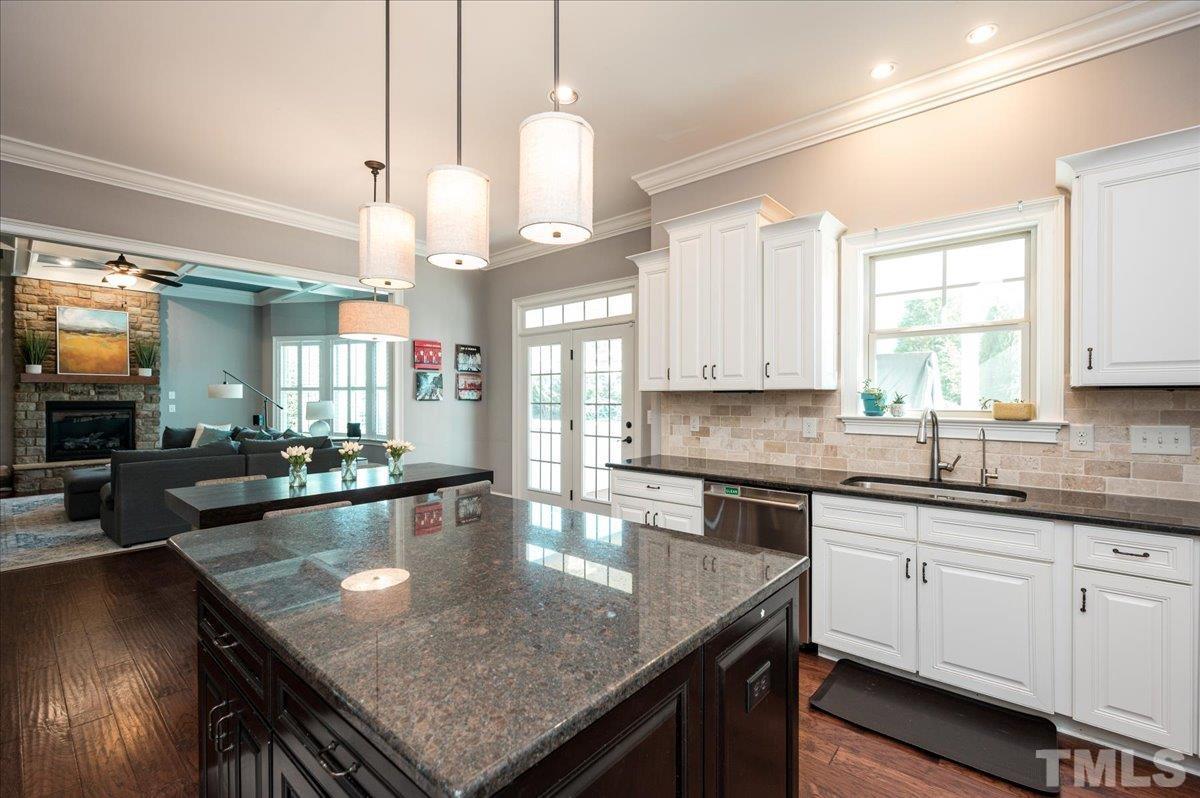5100 Gansett Lane Raleigh, NC 27612 - Photo 4 of 39 a kitchen with kitchen island granite countertop a sink a counter space appliances and cabinets