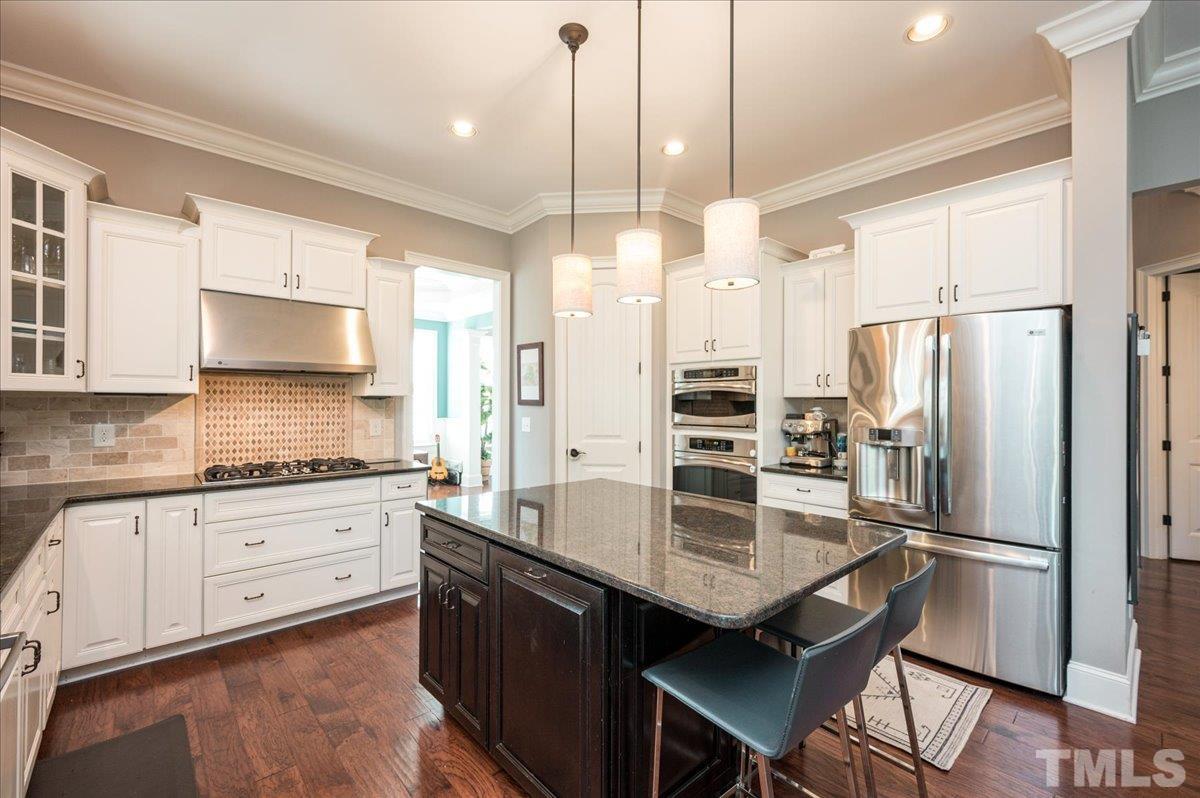 5100 Gansett Lane Raleigh, NC 27612 - Photo 6 of 39 a kitchen with granite countertop a center island a counter space stainless steel appliances and cabinets