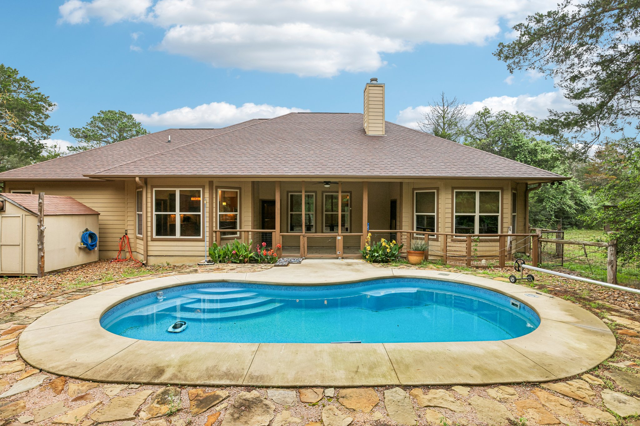 267 Corral Road Smithville, TX 78957 - Photo 3 of 40 Curved inground pool with concrete coping and flagstone surround