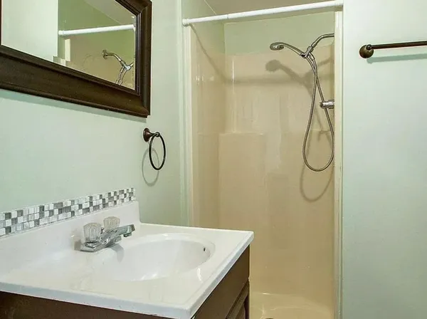 a bathroom with a granite countertop sink and a white door