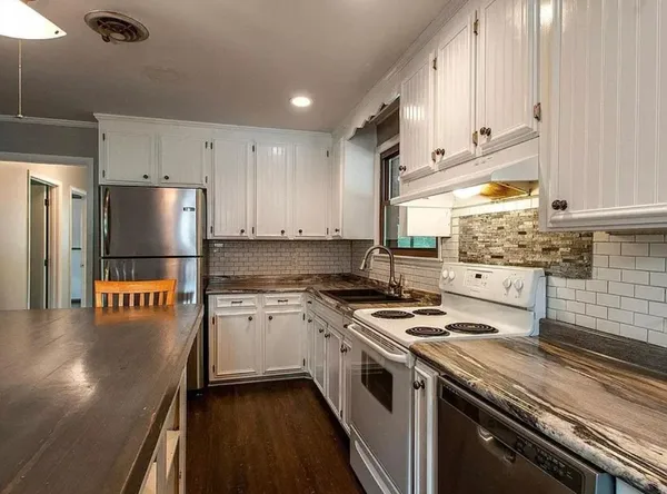 a kitchen with stainless steel appliances granite countertop a stove a refrigerator and a stove