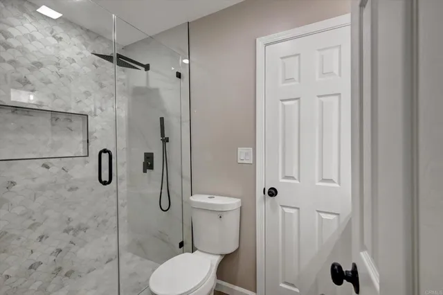 a bathroom with a toilet and a shower