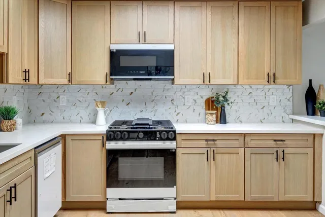 a bathroom with a granite countertop sink a toilet and bathtub