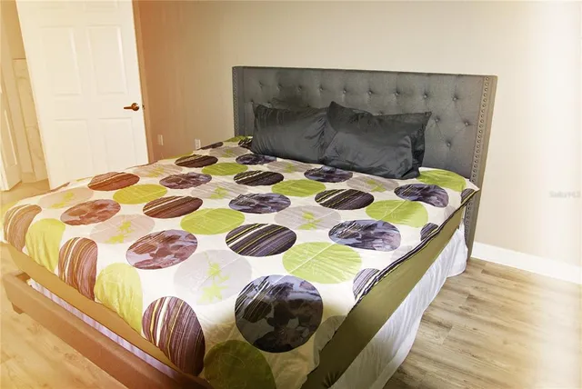 a bedroom with a bed and a painting on the wall