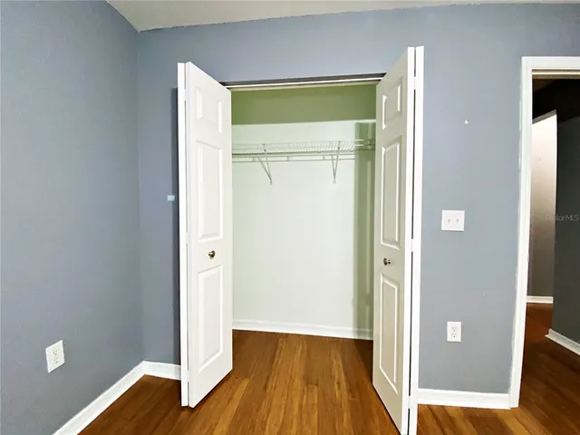 an empty room with wooden floor and a window