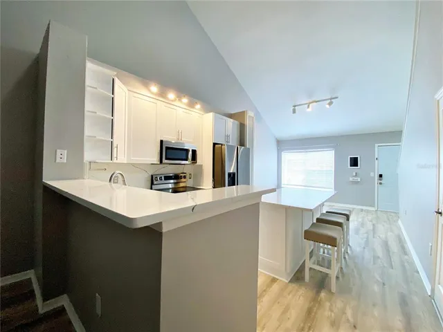 a large white kitchen with a table and chairs in it