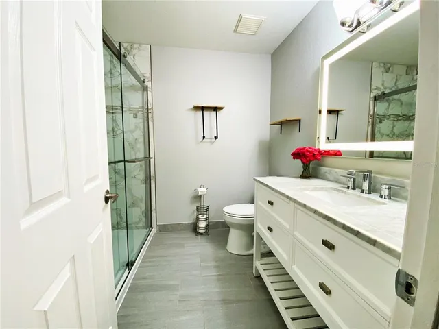 a bathroom with a double vanity sink toilet and shower