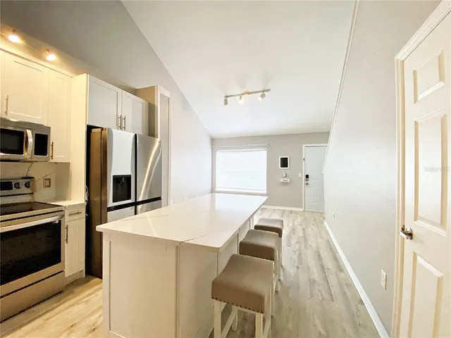 a kitchen with stainless steel appliances a refrigerator and a stove top oven