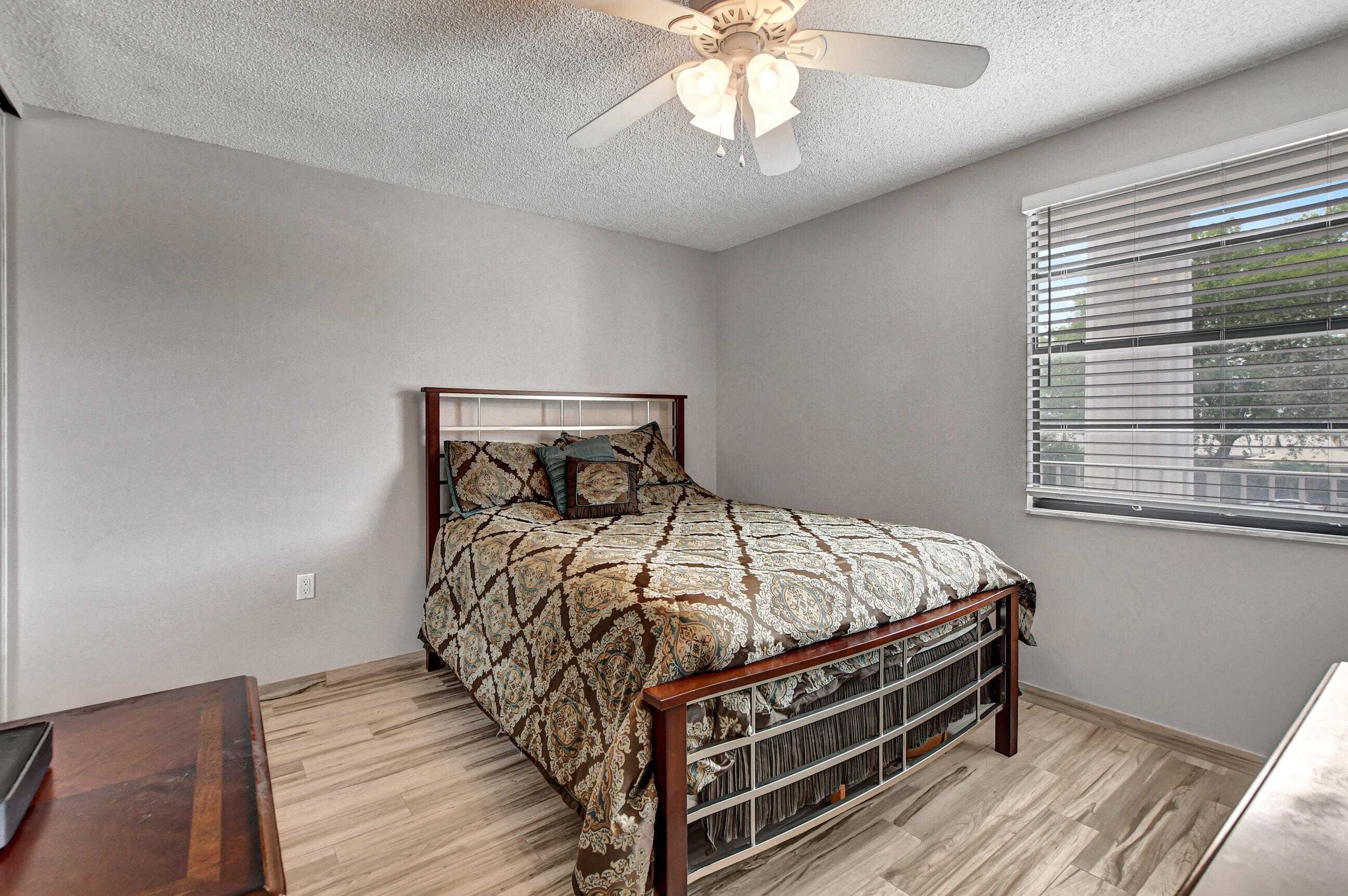 6025 Balboa Circle, Unit 304 Boca Raton, FL 33433 - Photo 15 of 38 a bedroom with a bed and a chandelier