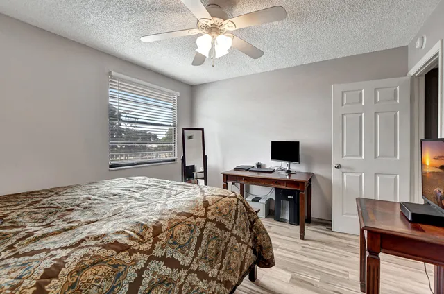 a bedroom that has a bed and a computer on a table