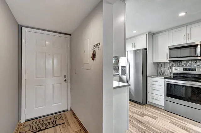 a kitchen with stainless steel appliances granite countertop a refrigerator and a stove top oven