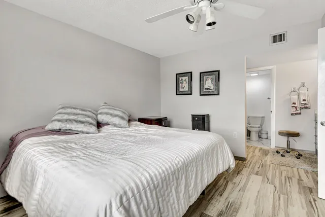 a spacious bedroom with a bed and painting on the wall