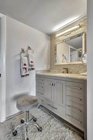 a bathroom with a granite countertop sink a mirror and a vanity
