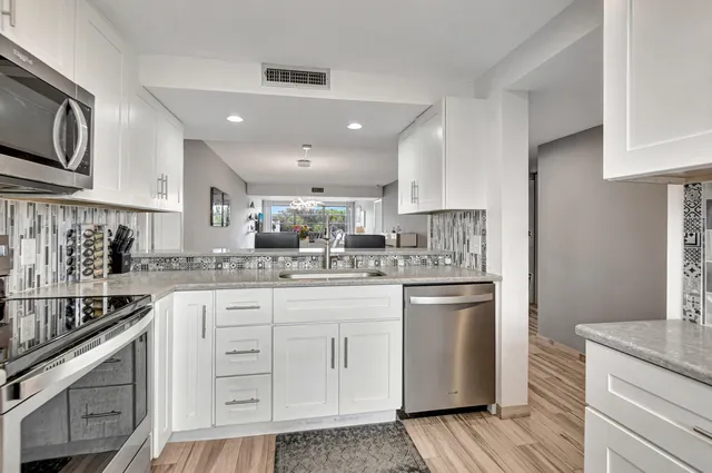 a kitchen with stainless steel appliances granite countertop a sink stove and refrigerator