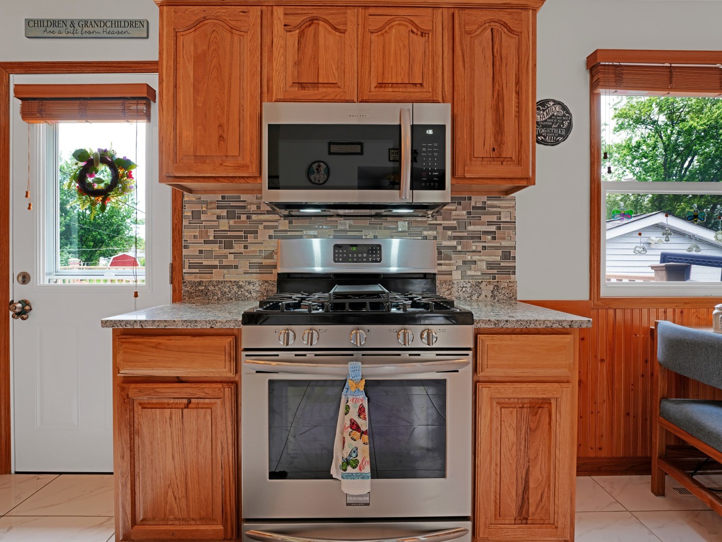 58 South Beck Road Lindenhurst, IL 60046 - Photo 8 of 37 a kitchen with granite countertop a stove top oven cabinetry a sink and a window