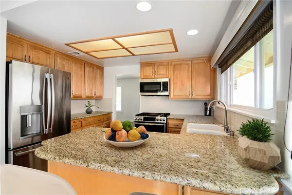 a kitchen with stainless steel appliances granite countertop a stove a refrigerator and a sink