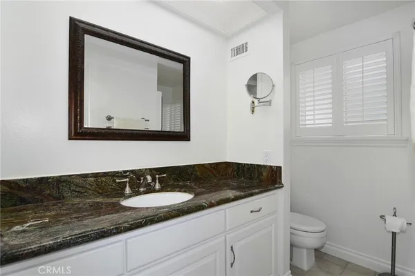 a bathroom with a granite countertop sink and a mirror