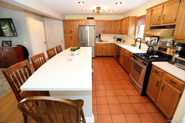 a large kitchen with stainless steel appliances a stove a sink dishwasher and cabinets